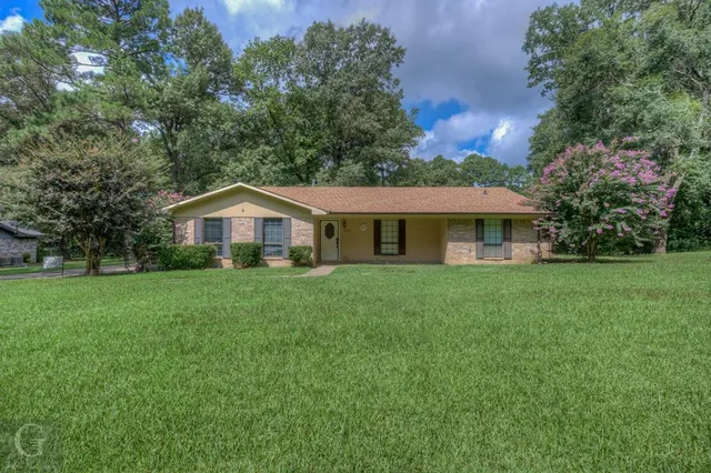 a front view of house with yard and green space