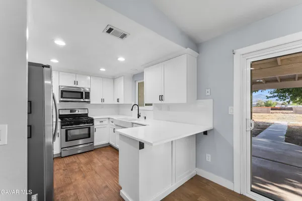 a kitchen with a sink stainless steel appliances and white cabinets