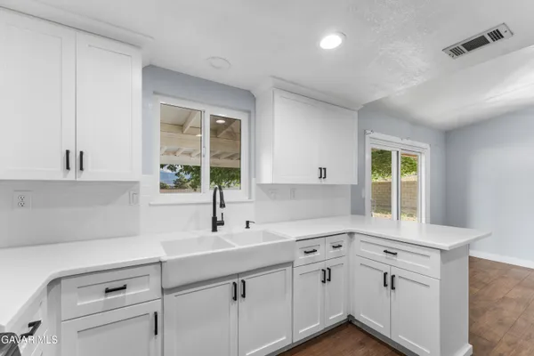 a kitchen with white cabinets and a sink