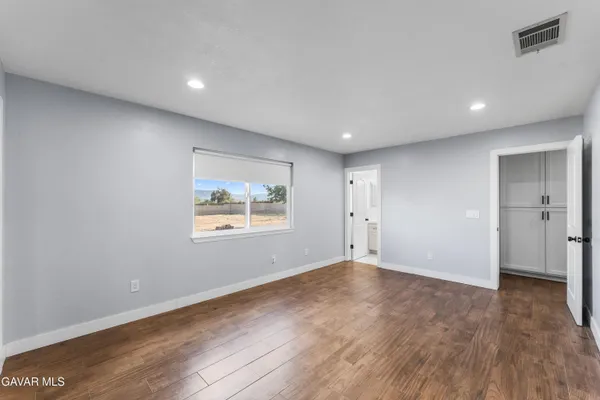 an empty room with wooden floor and window
