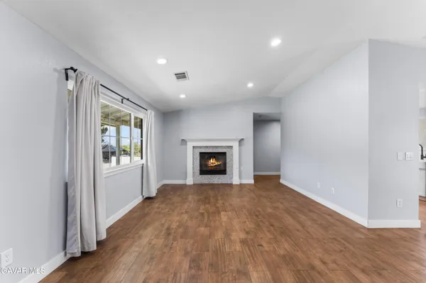 a view of an empty room with a window and fireplace