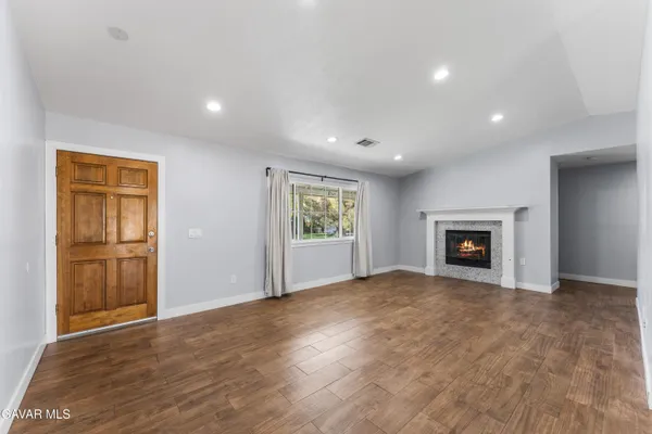 a view of an empty room with window and cabinet