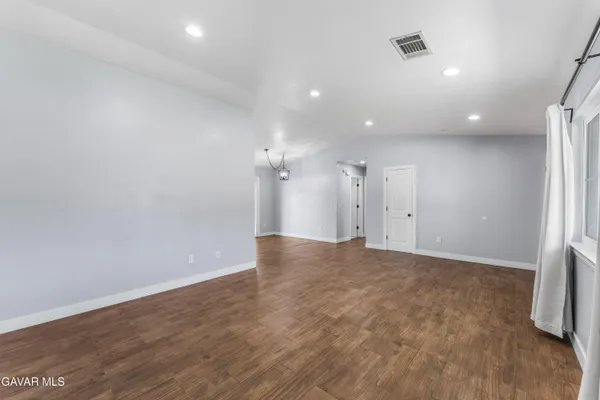 an empty room with wooden floor and a window