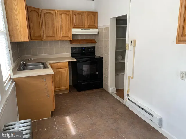 a kitchen with a refrigerator and a stove top oven