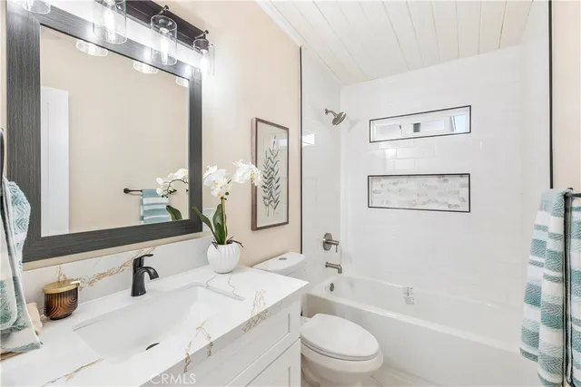 a bathroom with a granite countertop sink mirror vanity and toilet