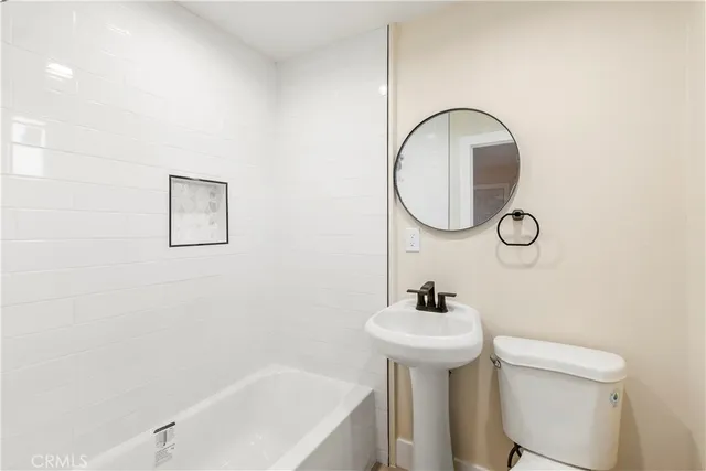a bathroom with a sink a toilet and a mirror