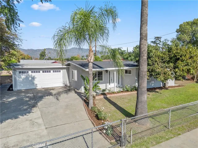 a view of a house with backyard and sitting area