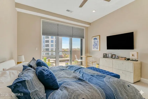 a bedroom with a bed and a flat screen tv on the dresser