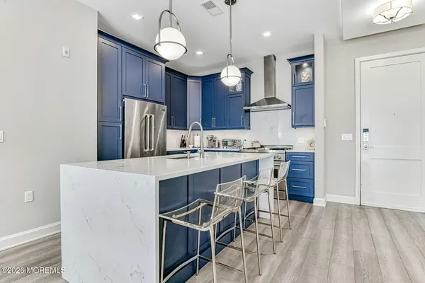 a kitchen with stainless steel appliances a table chairs refrigerator and microwave