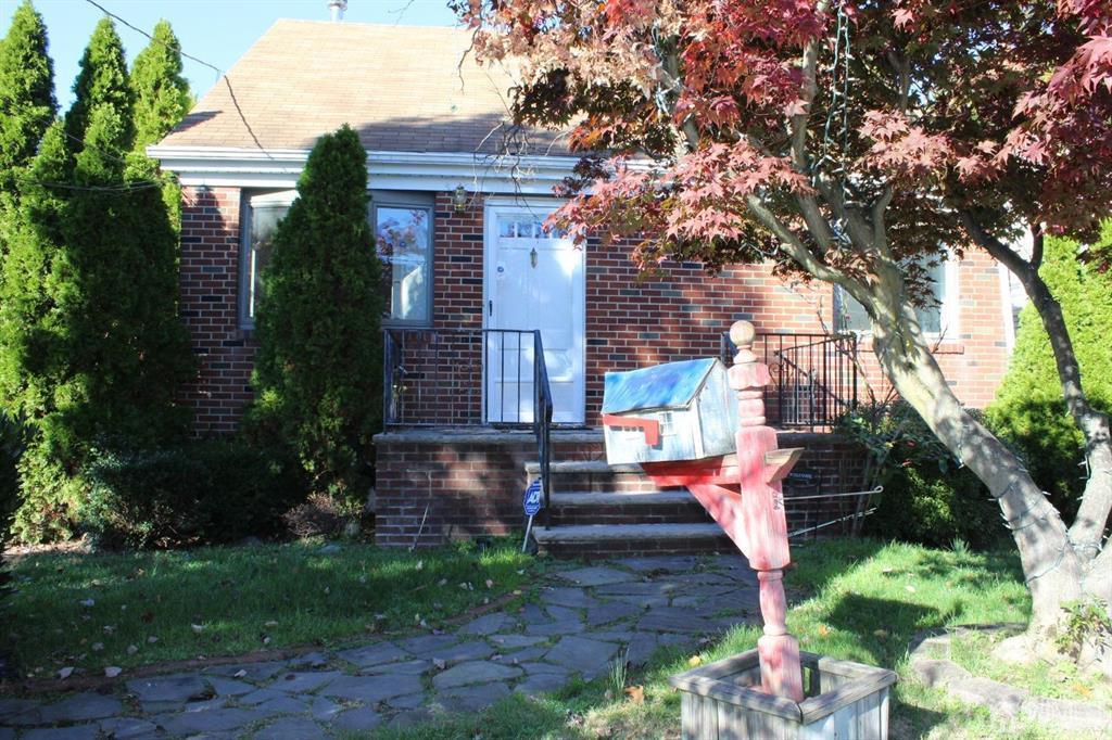 a front view of house with a garden
