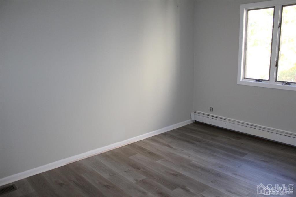 8 Maple Road Iselin, NJ 08830 - Photo 15 of 21 an empty room with wooden floor and windows