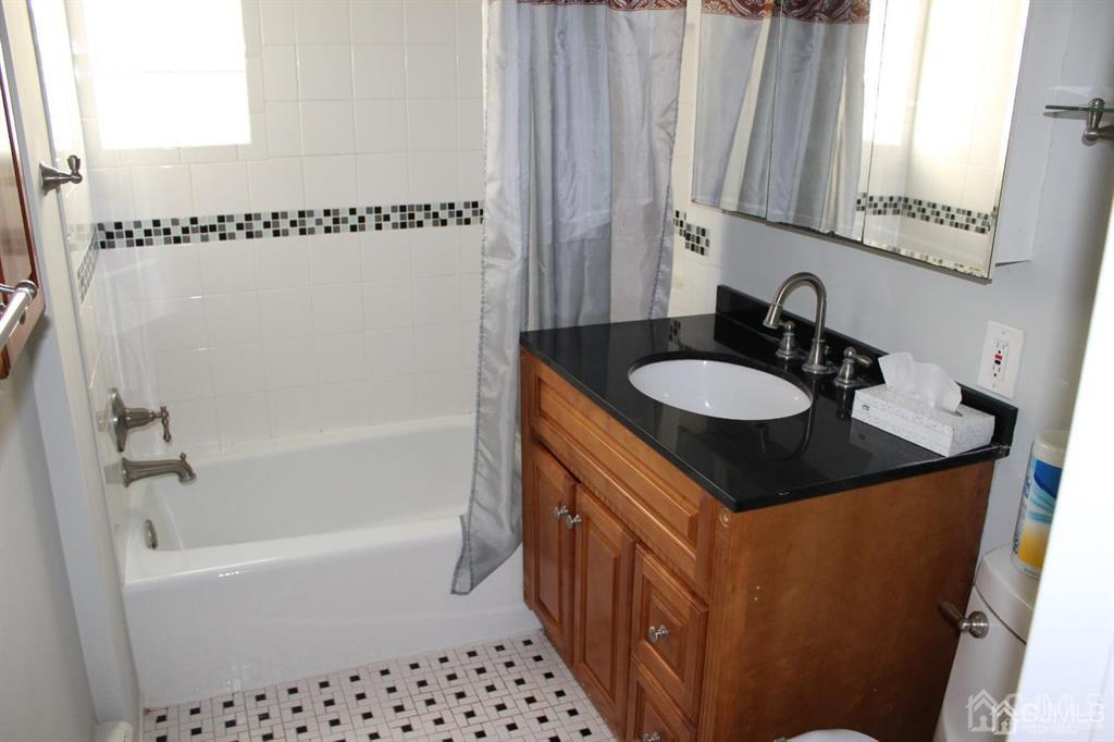 8 Maple Road Iselin, NJ 08830 - Photo 17 of 21 a bathroom with a sink a mirror and a bathtub