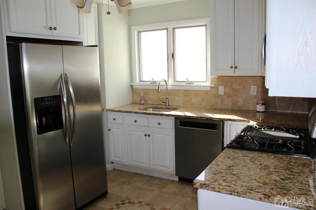 8 Maple Road Iselin, NJ 08830 - Photo 6 of 21 a kitchen with a refrigerator sink and cabinets