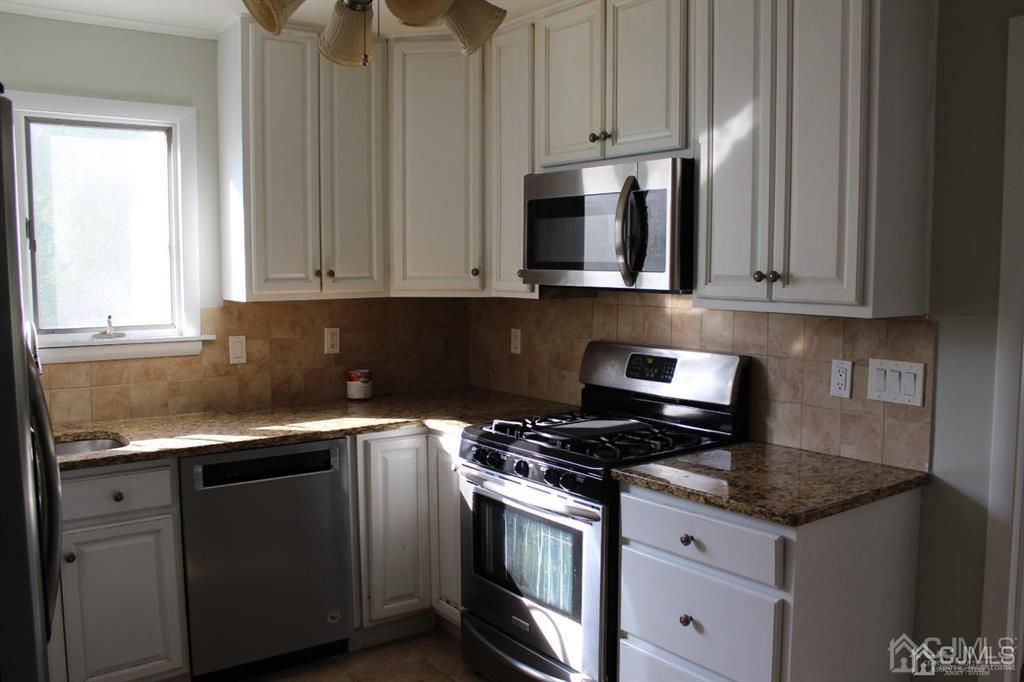 8 Maple Road Iselin, NJ 08830 - Photo 7 of 21 a kitchen with granite countertop white cabinets and stainless steel appliances