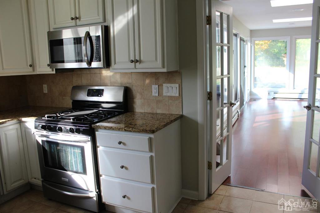 8 Maple Road Iselin, NJ 08830 - Photo 9 of 21 a kitchen with stainless steel appliances granite countertop a stove and a refrigerator
