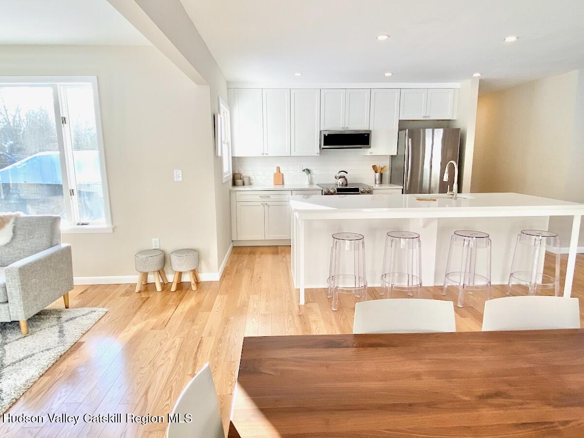 132 Weeds Mill Road Highland, NY 12528 - Photo 6 of 37 a large white kitchen with stainless steel appliances granite countertop a stove a sink a refrigerator and white cabinets with wooden floor