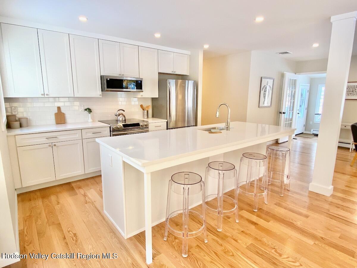 132 Weeds Mill Road Highland, NY 12528 - Photo 7 of 37 a kitchen with stainless steel appliances a sink a stove a refrigerator cabinets and a window