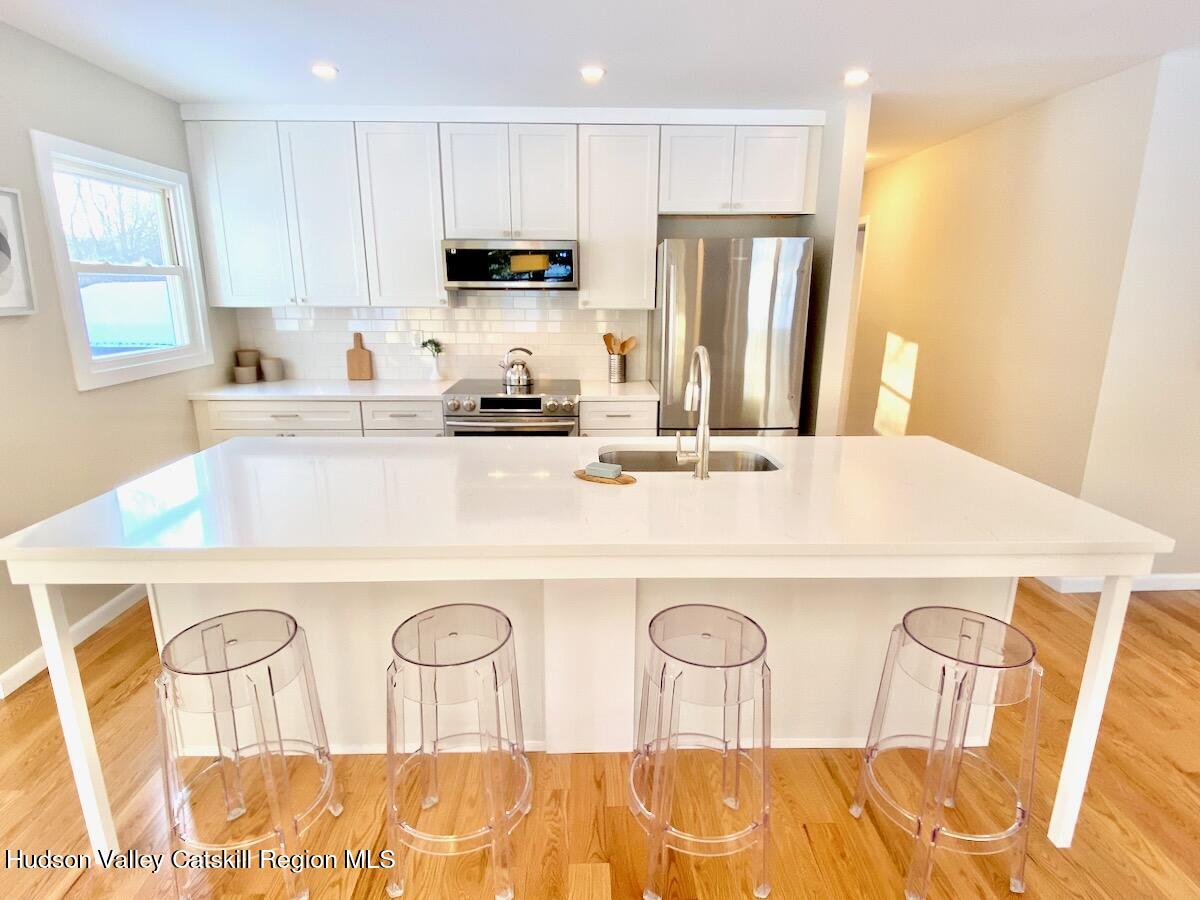 132 Weeds Mill Road Highland, NY 12528 - Photo 10 of 37 a kitchen with stainless steel appliances a sink a stove a refrigerator with white cabinets