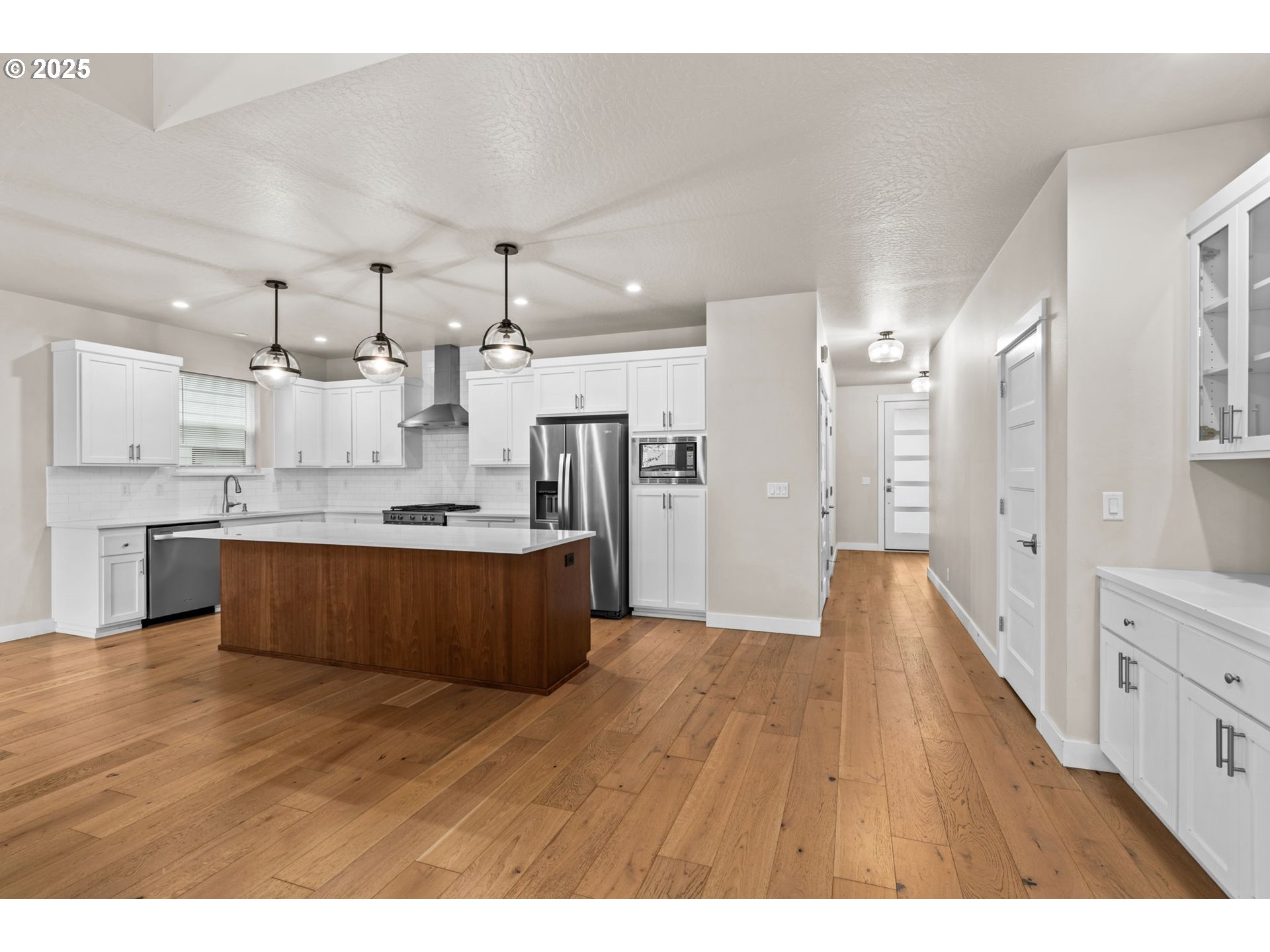 1030 53rd Place Springfield, OR 97478 - Photo 4 of 39 a large kitchen with stainless steel appliances kitchen island a large counter top and a wooden floors