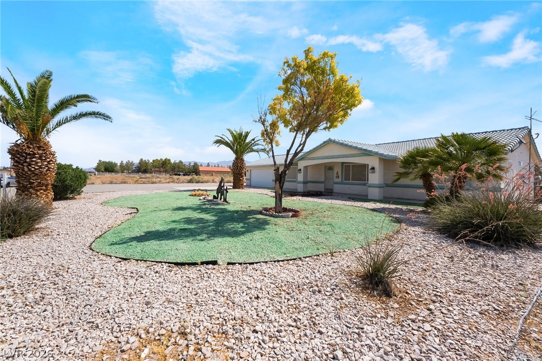 3631 South Blagg Road Pahrump, NV 89048 - Photo 45 of 47 A desert oasis with a manicured front yard, a welcoming entry, and a wide driveway.