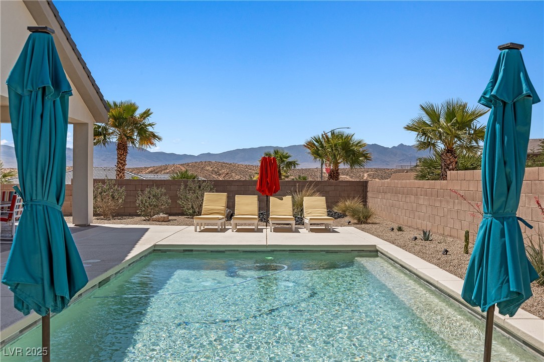 1357 Manassas Ridge Mesquite, NV 89027 - Photo 49 of 72 View of pool featuring a mountain view, a fenced backyard, and a patio area