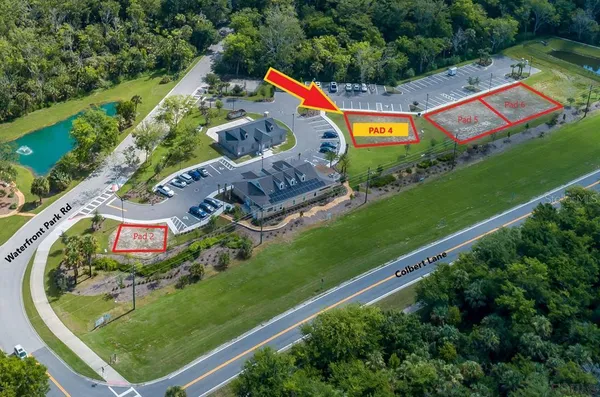 an aerial view of a tennis ground and a cars park side of the road