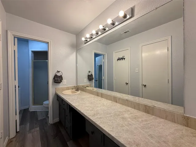 a bathroom with a granite countertop sink and a mirror