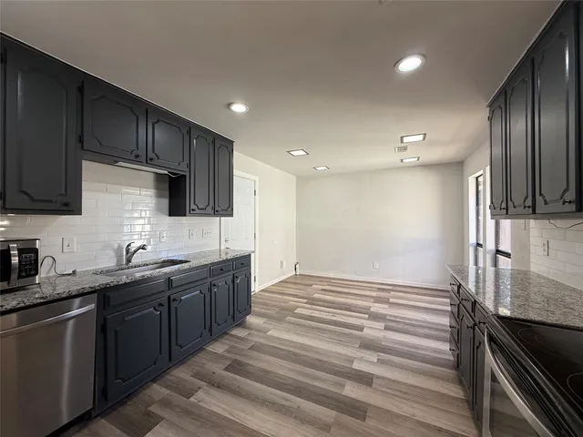 a kitchen with stainless steel appliances granite countertop a sink stove and refrigerator