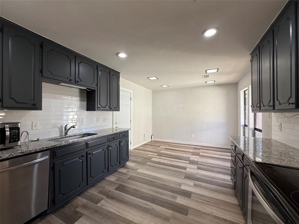 3515 Hilltop Lane Plano, TX 75023 - Photo 4 of 19 a kitchen with stainless steel appliances granite countertop a sink stove and refrigerator