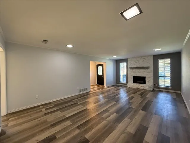 an empty room with wooden floor and fireplace