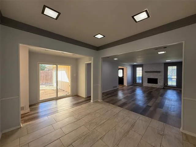 a view of a livingroom with wooden floor and a fireplace
