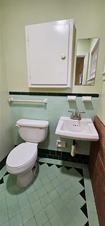 a bathroom with a toilet a sink and mirror