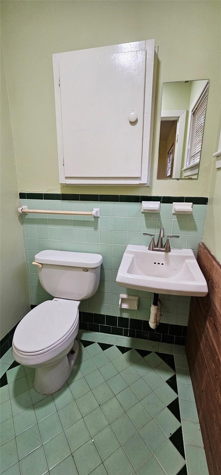 3610 Dennis Street Houston, TX 77004 - Photo 8 of 16 a bathroom with a toilet a sink and mirror