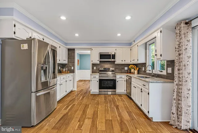 a kitchen with granite countertop a refrigerator stove and sink