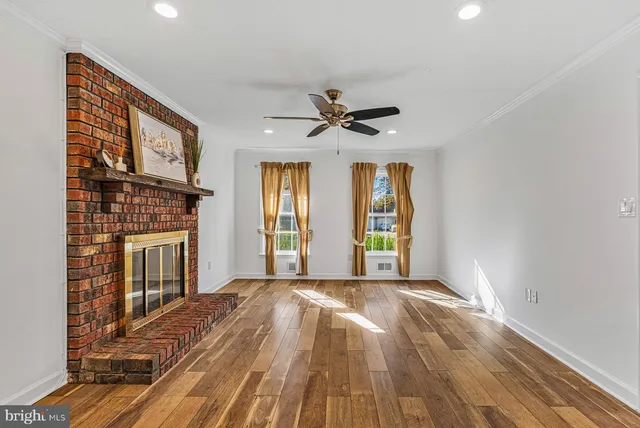a view of an empty room with a fireplace and a window