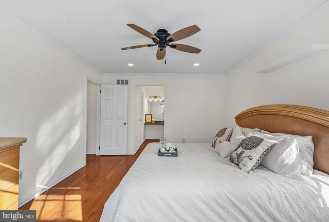 a bedroom with a bed and a ceiling fan