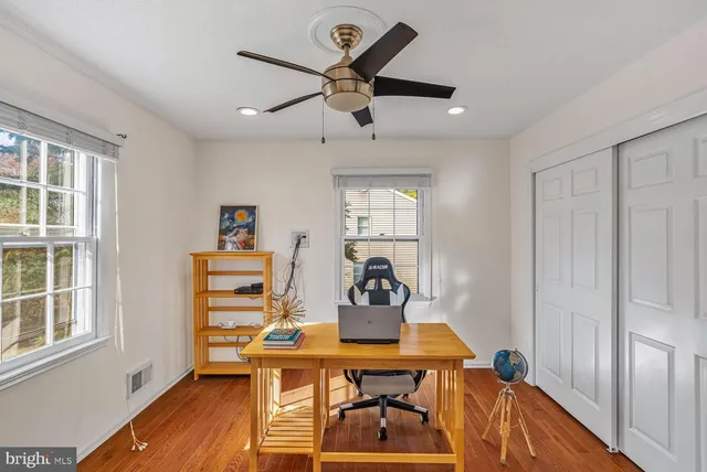 a view of a workspace with furniture and a window