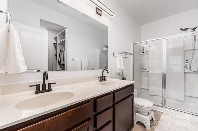 a bathroom with a sink a toilet and shower