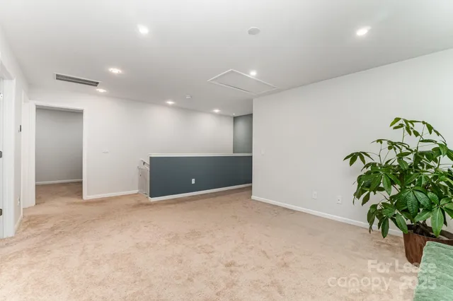 an empty room with potted plants and wooden floor