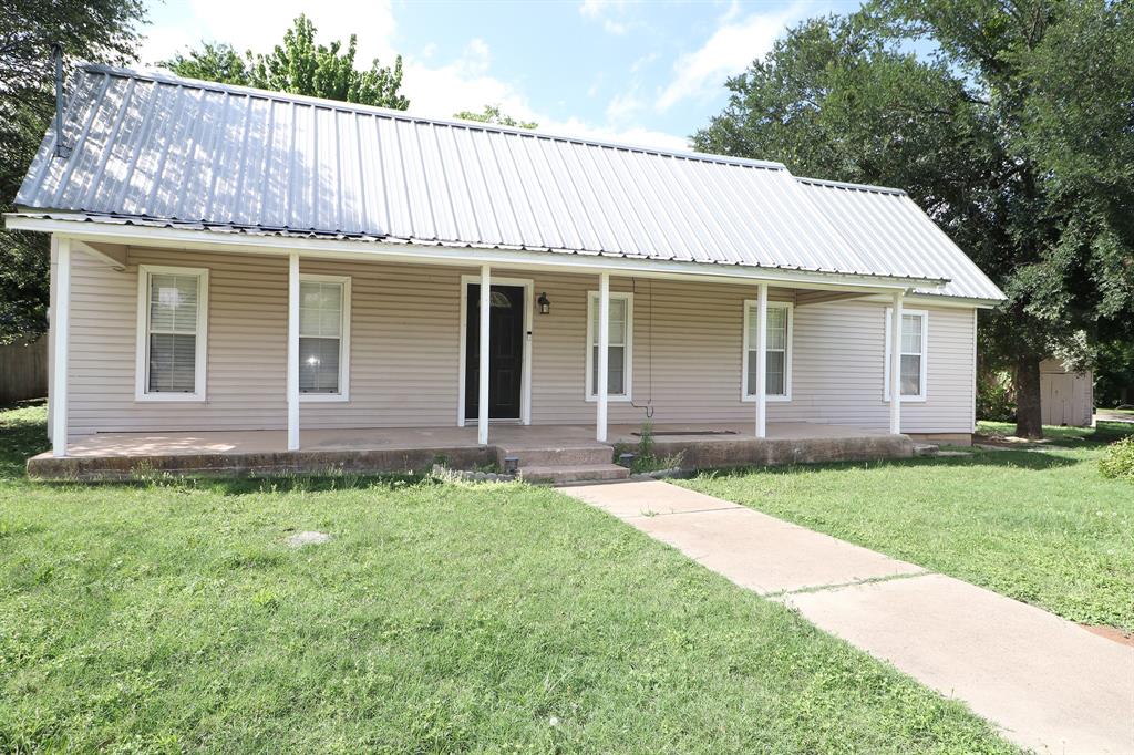 1065 West Pecan Street Stephenville, TX 76401 - Photo 1 of 40 Farmhouse featuring metal roof, covered porch, and a front yard