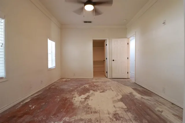 an empty room with closet and windows