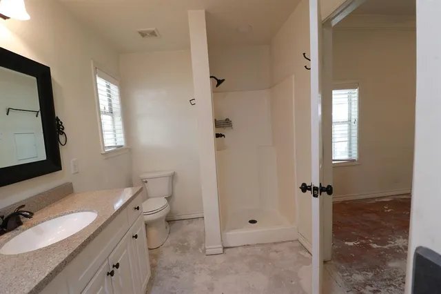 a bathroom with a double vanity sink toilet mirror and shower