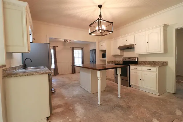 a kitchen with kitchen island granite countertop appliances cabinets and a sink