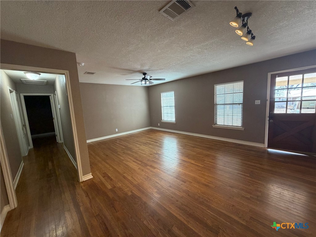 127 Hillcrest Drive Luling, TX 78648 - Photo 3 of 26 wooden floor in an empty room with a window
