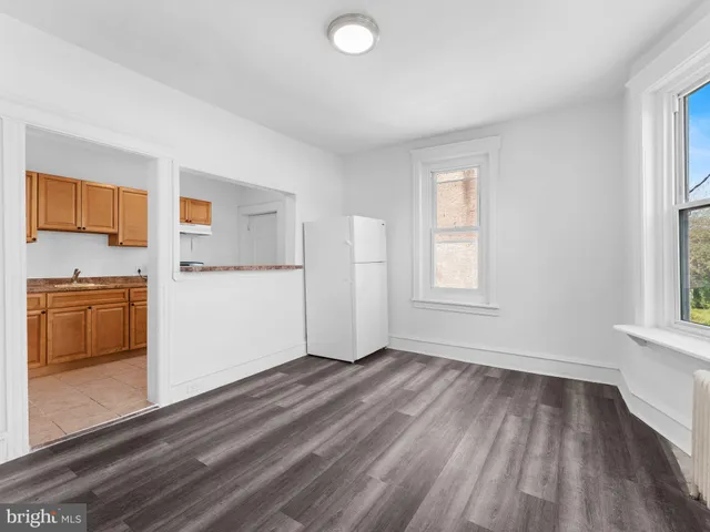 a view of a kitchen with wooden floor and electronic appliances