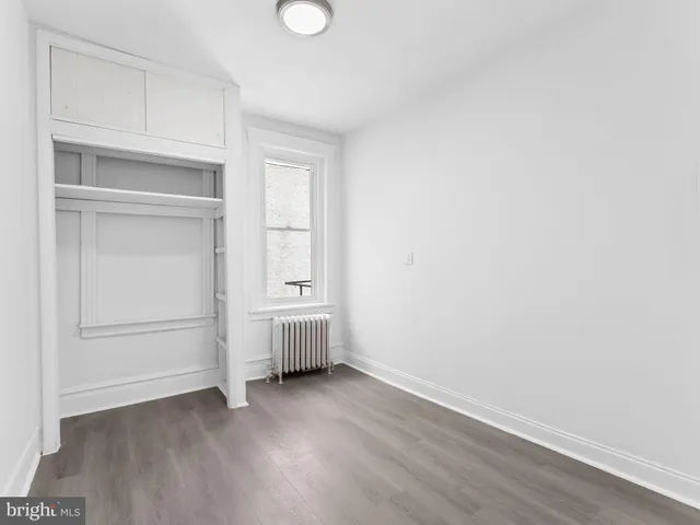 a view of an empty room with cabinet and utility room