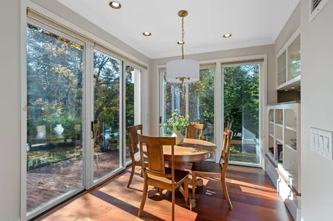a dining room with furniture wooden floor and a floor to ceiling window