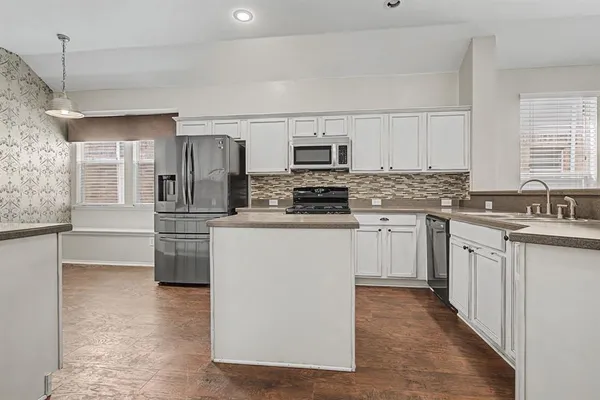 a kitchen with stainless steel appliances a refrigerator sink and microwave