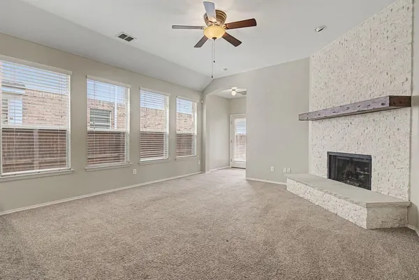 a view of an empty room with a fireplace and a window
