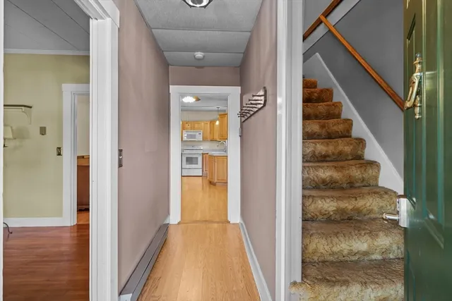a view of a hallway with wooden floor and staircase
